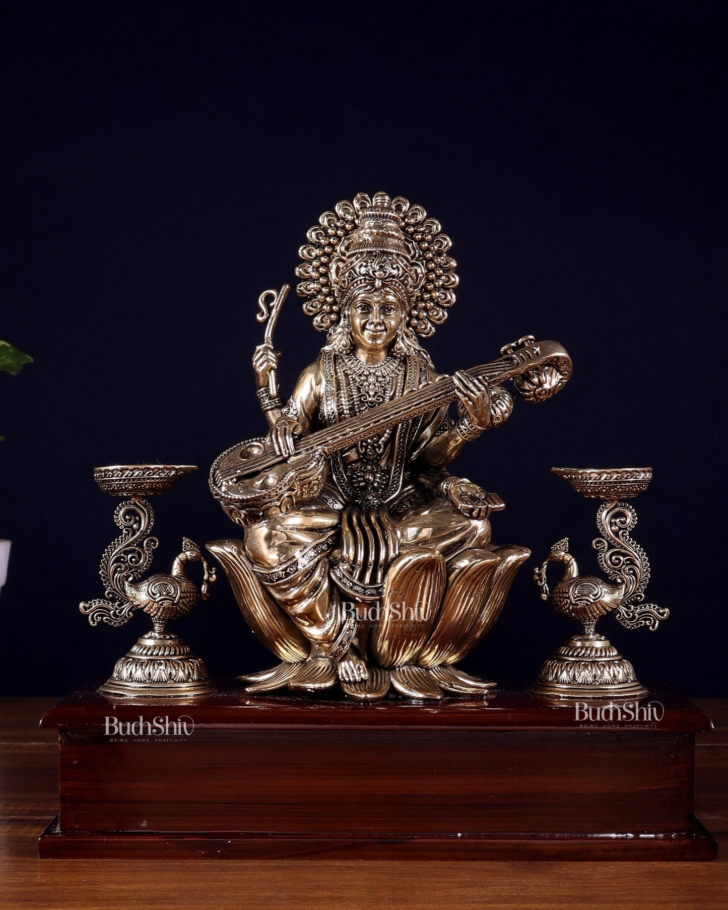 Brass Superfine Goddess Saraswati Idol with Twin Peacock Lamps on Wooden Base – 9.5 Inch
