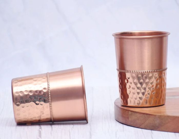 எங்கள் கைவினைஞர்களால் செய்யப்பட்ட சுத்தியல் செம்பு கண்ணாடி மூலம் பாரம்பரிய ஆரோக்கியத்தின் நன்மைகளை அனுபவியுங்கள். தூய தாமிரத்தால் ஆன இந்த நேர்த்தியான டம்ளர், உங்கள் அன்றாட நீரேற்றத்திற்கு பழமையான அழகைச் சேர்ப்பதோடு, நீரின் தரத்தையும் மேம்படுத்துகிறது.